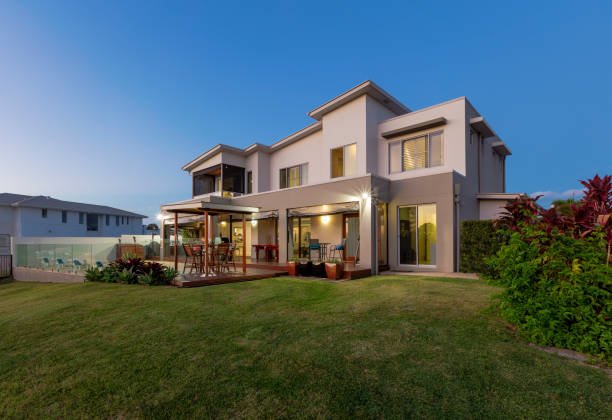 Home modern multilevel house exterior with pool at dusk